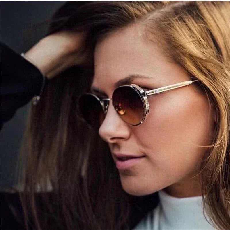 Woman wearing round brown gradient sunglasses with metal frames, stylish eyewear close-up