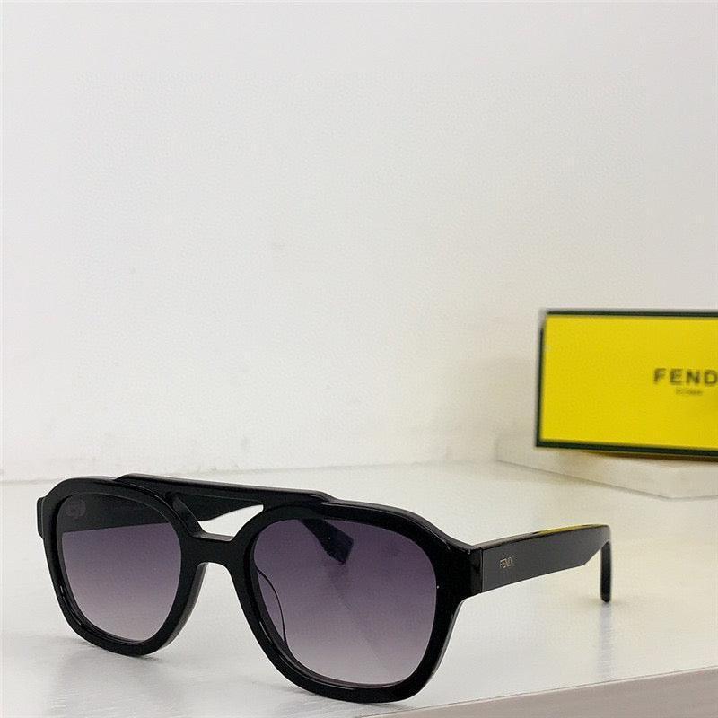 Black designer sunglasses with dark gradient lenses and a bold frame on a white surface.