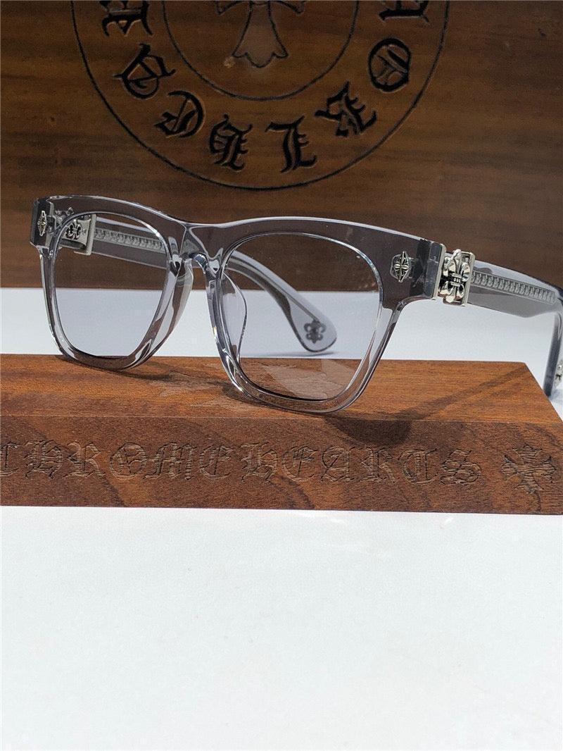 Clear rectangular eyeglasses with silver accents on wooden display, luxury eyewear fashion