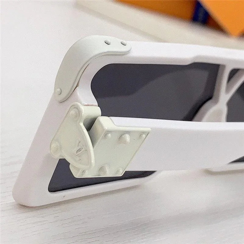 Close-up of white sunglasses with dark lenses and unique rivet hinge detail on frame