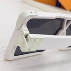 Close-up of white sunglasses with dark lenses and unique rivet hinge detail on frame