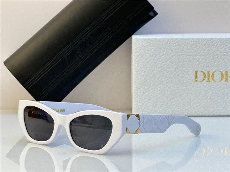 White cat-eye sunglasses with dark lenses and gold accents, fashion accessory with case and box