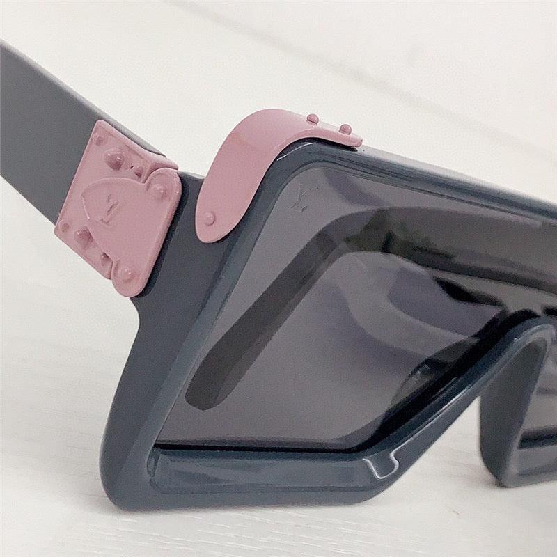 Close-up of stylish square sunglasses with grey frame, pink accents, and tinted lenses