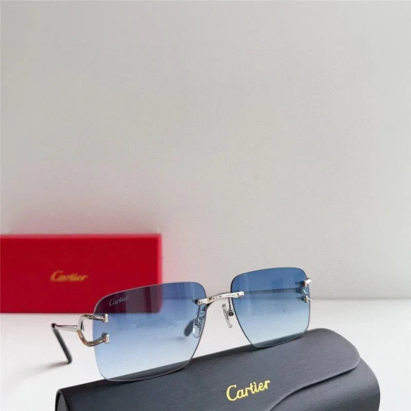 Blue gradient rimless sunglasses with silver temples on a black Cartier case, red box in background