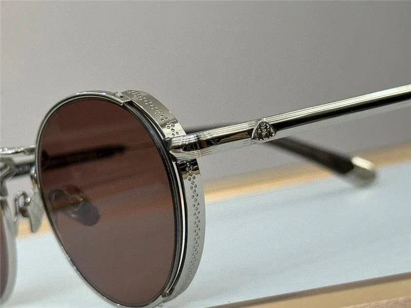 Close-up of round sunglasses with silver metal frame and brown tinted lenses