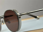 Close-up of round sunglasses with silver metal frame and brown tinted lenses