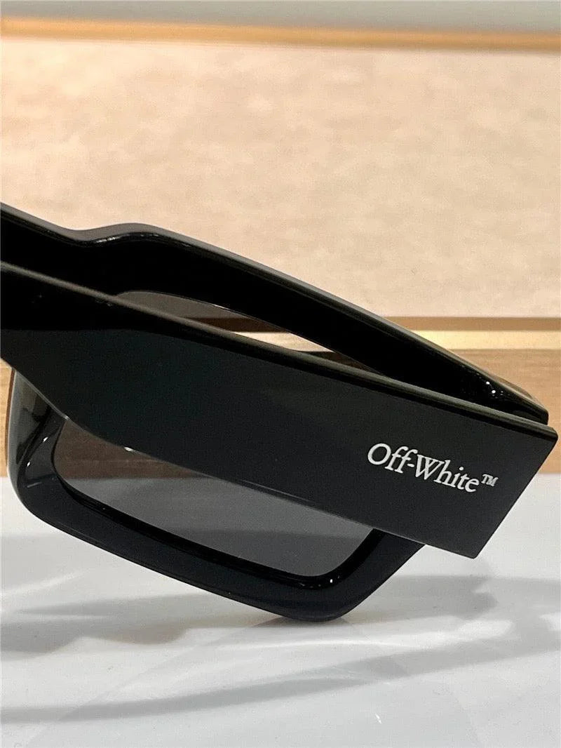 Black angular sunglasses with tinted lenses, visible Off-White logo on the temple