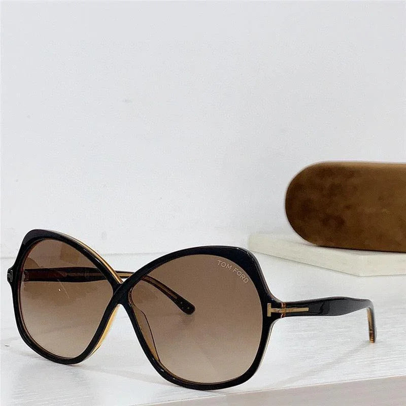 Oversized black sunglasses with brown gradient lenses, butterfly frame, and hard case