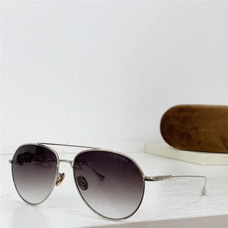 Aviator sunglasses with gradient lenses and silver metal frame, brown case in background