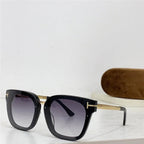 Black square oversized sunglasses with gold temples and gradient lenses on a white surface