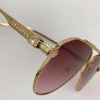 Gold aviator sunglasses with engraved temples and purple tinted lenses on white background