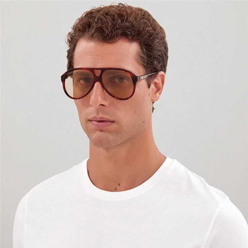 Man wearing oversized square brown sunglasses with gradient lenses and white t-shirt